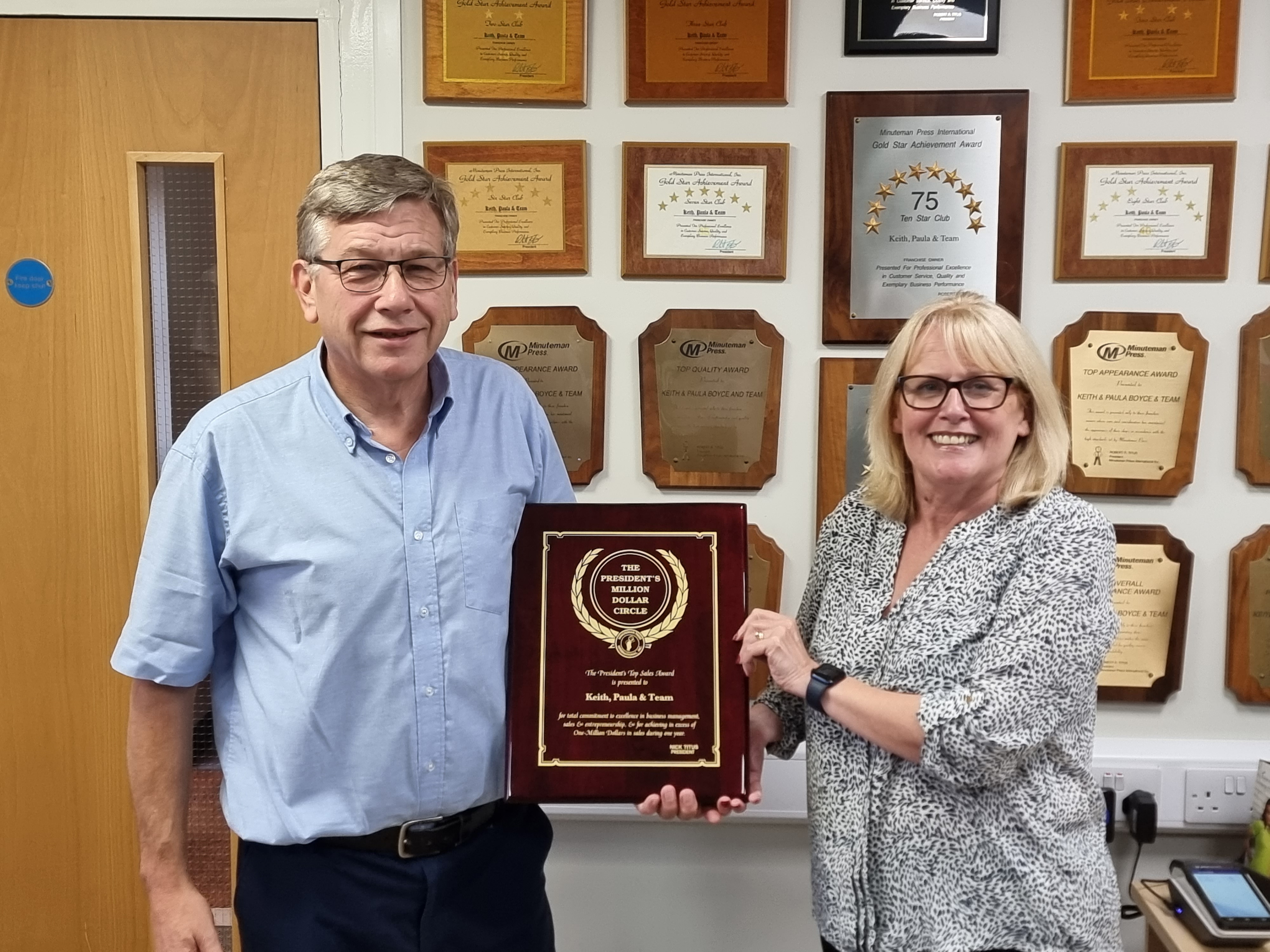 Minuteman Press franchise owners Keith and Paula Boyce with their Presidents Club plaque in Kings Lynn, England.